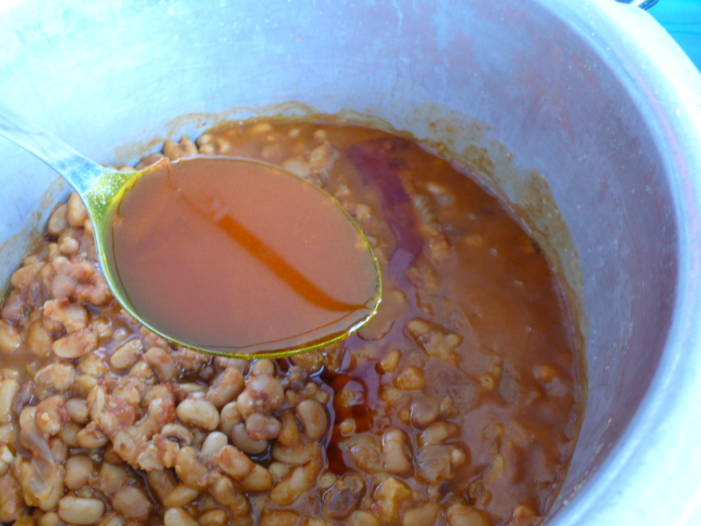 pouring palm oil in nigerian beans pottage